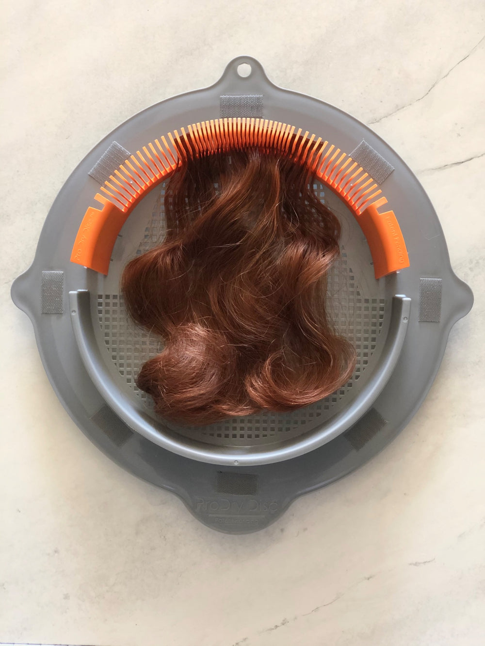Brown hairpiece supported by ProDry Disc styling accessory